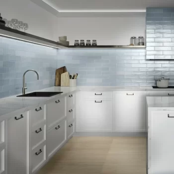 Kitchen featuring Acqua subway tiles as a backsplash with sleek white cabinetry.